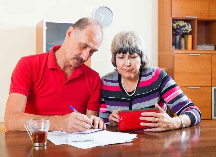Senior couple reviewing paperwork, planning downsizer super contributions.
